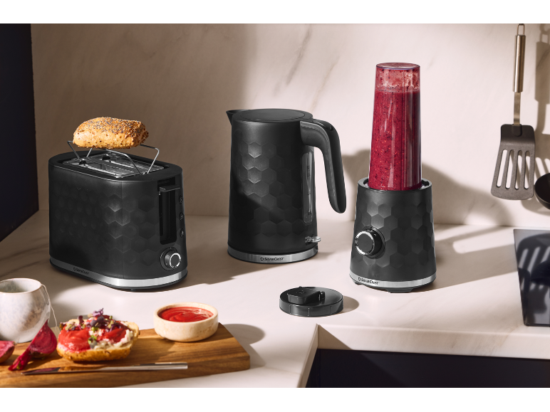 Must röster, veekeetja ja blender smuutiga köögiletil.