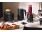 Must röster, veekeetja ja blender smuutiga köögiletil.