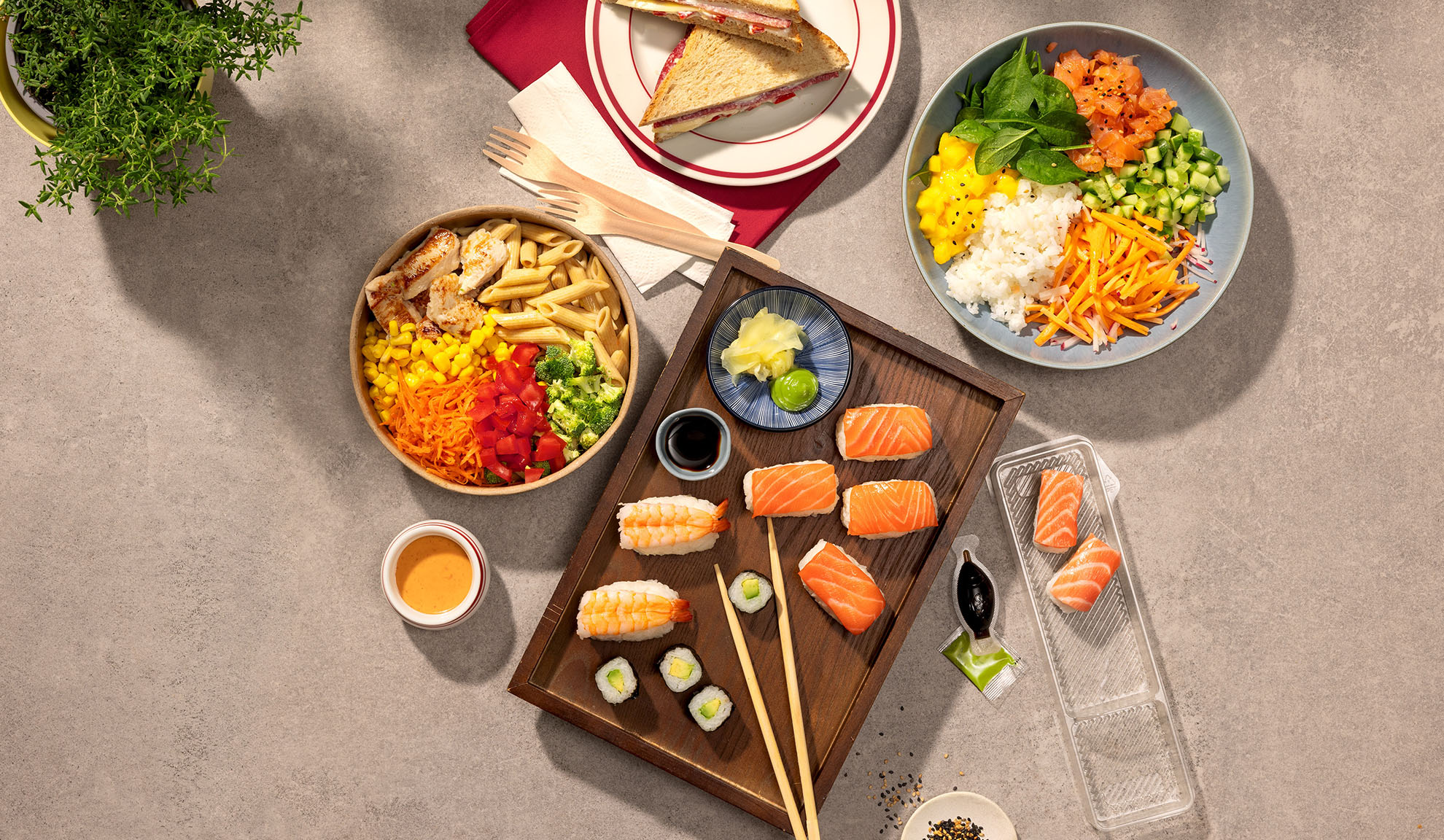 Ülevalt vaade erinevatele kaasavõetavatele toitudele: sushi, poke kauss, pastasalaat ja võileivad.