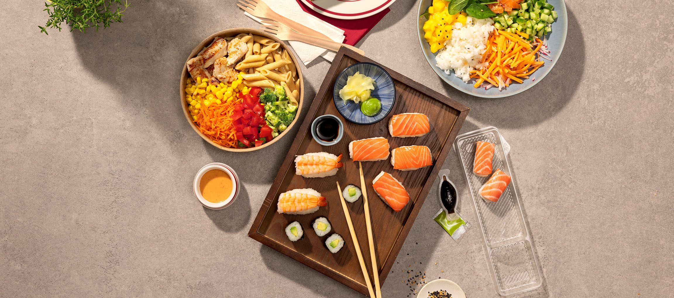 Erinevad toidud: pasta- ja kanakauss, sushi ja poke kauss laual.