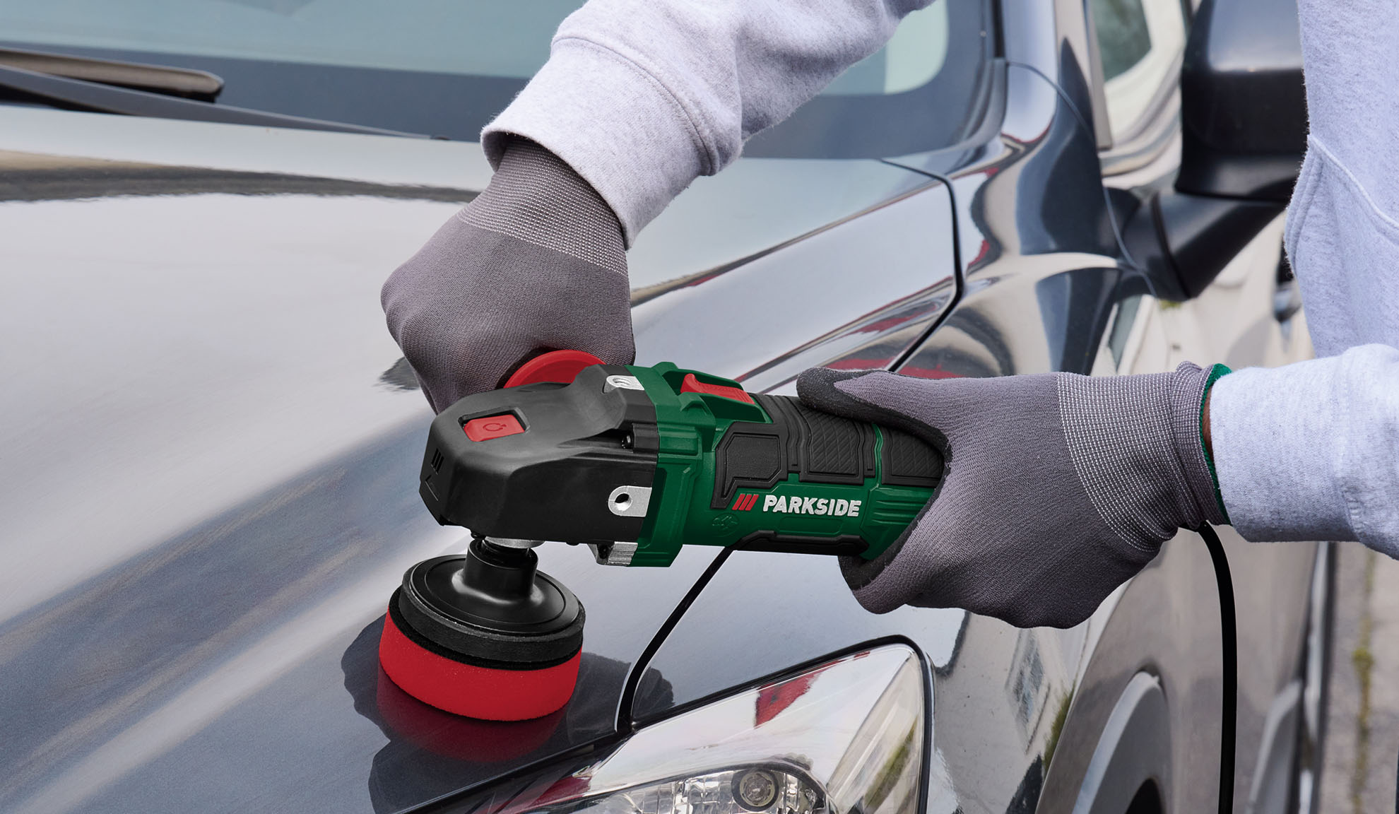 Inimene poleerib auto kapotti Parkside poleerijaga.
