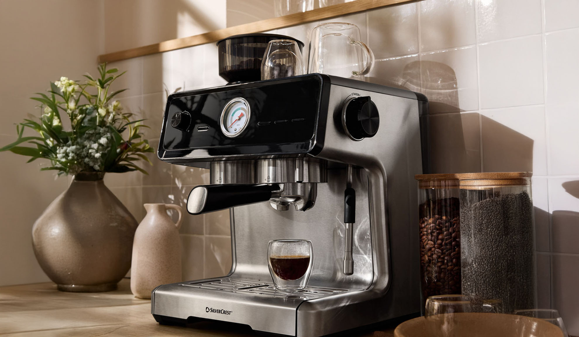 SilverCrest espressomasin köögilaual kohviubade ja chia seemnetega.