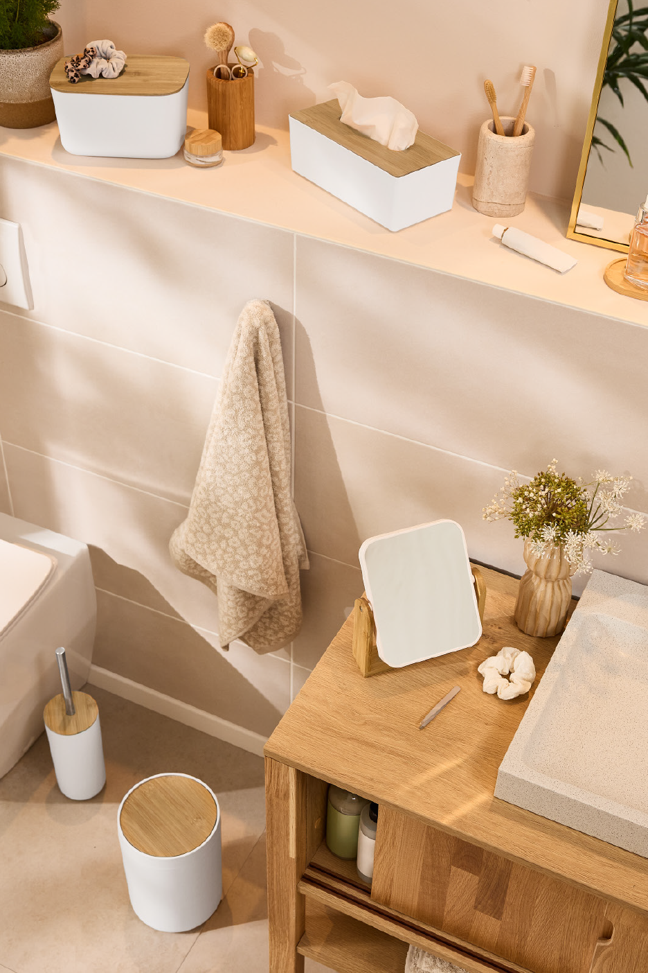 Vannitoa aksessuaarid: bambusest kaanega karbid, hambaharjad, peegel ja rätik.