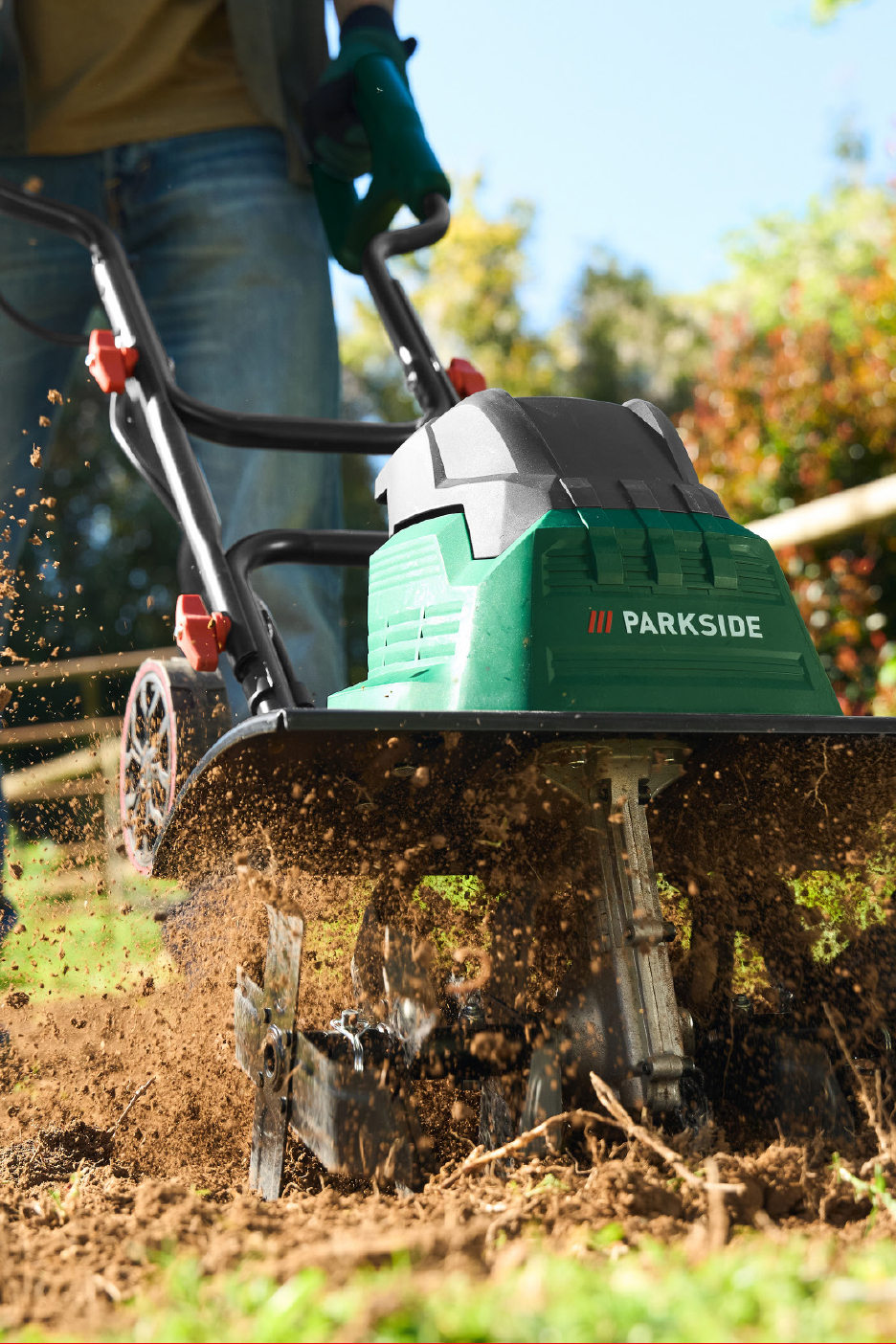 Teksades ja kinnastes inimene kasutab rohelist mullafreesi, mis kobestab mulda.