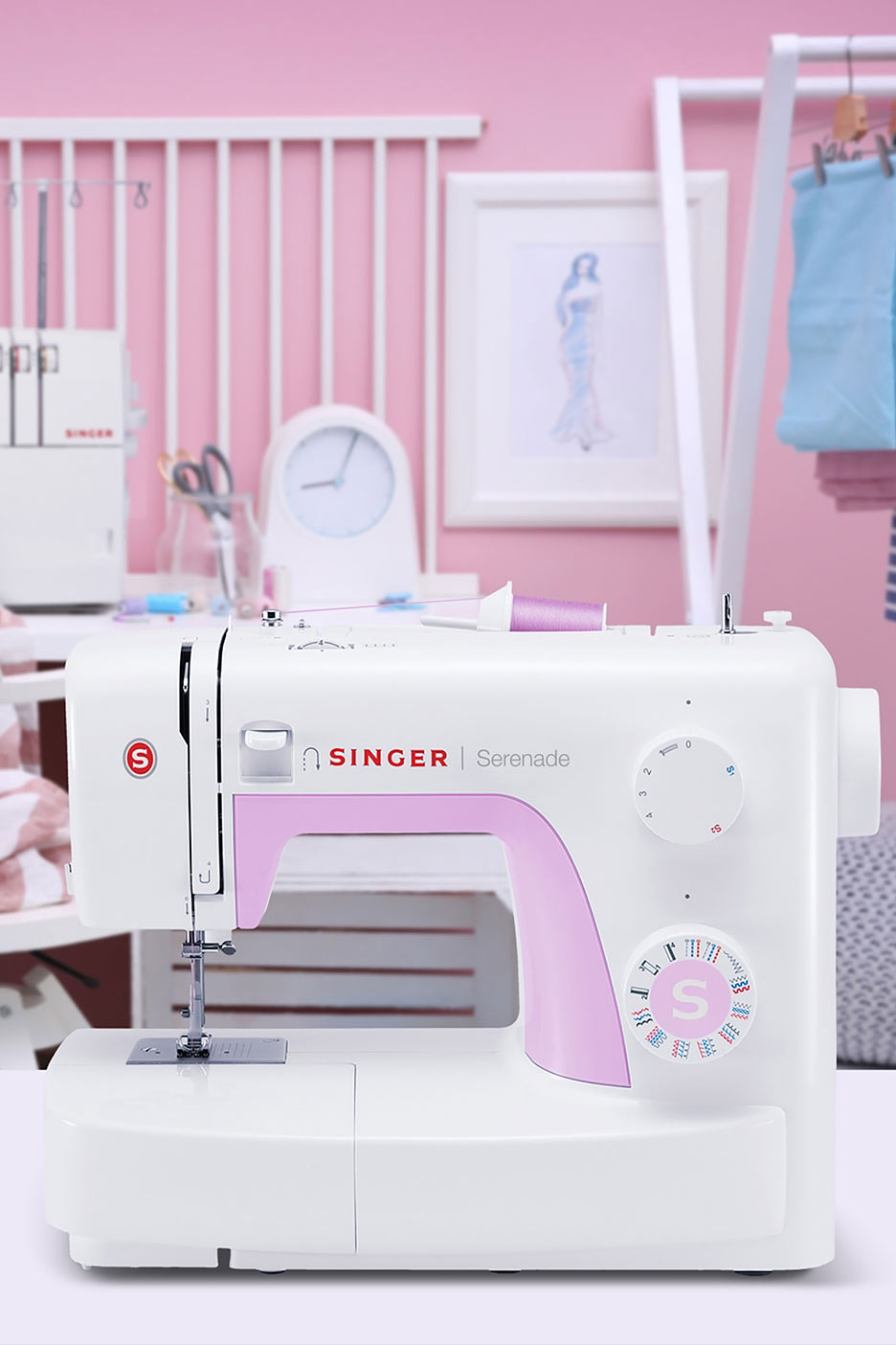 Valge õmblusmasin roosade aktsentidega laual roosas toas.