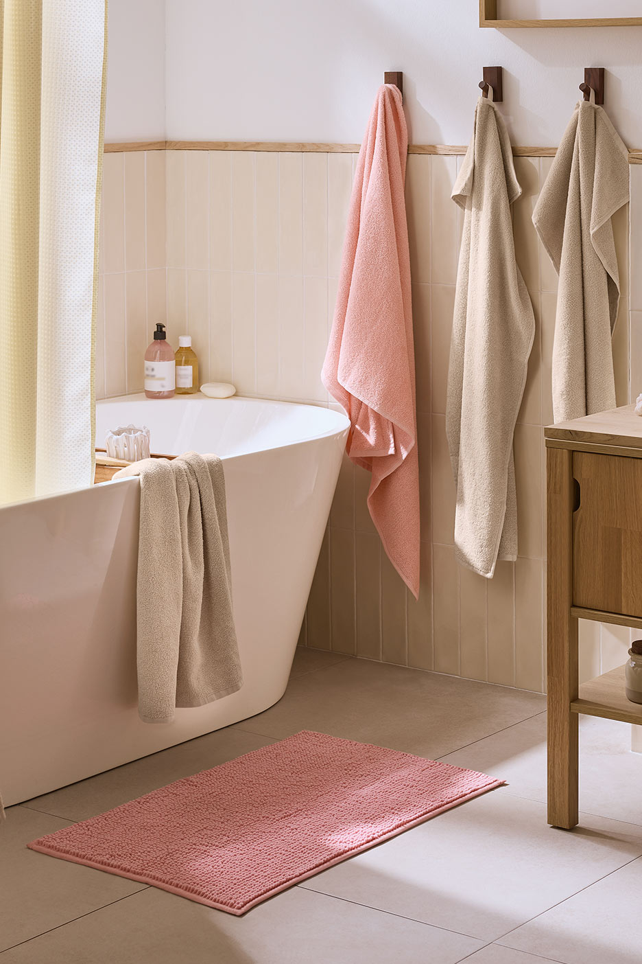 Vannituba roosa vannimati, vannirätikute ja vanniga.