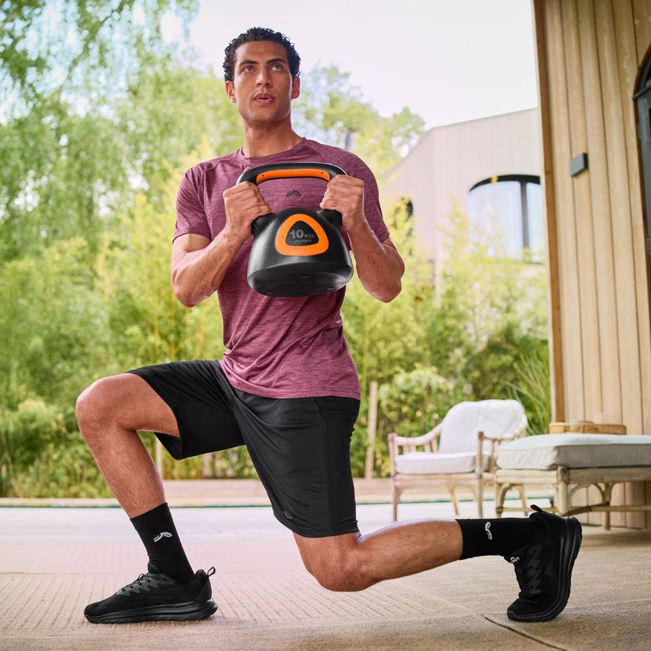 Mees teeb kükke 10 kg sangpommiga õues.
