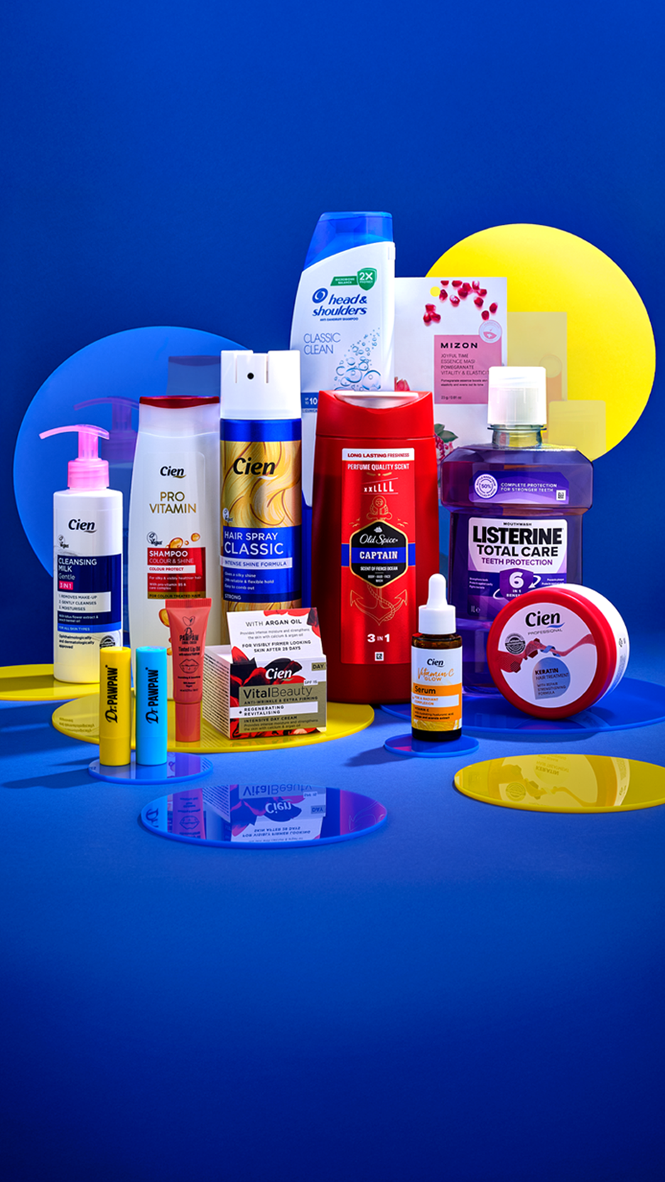 Valik hügieenitooteid, sealhulgas Head & Shoulders šampoon, Cien juuksehooldusvahendid ja Listerine suuvesi, sinisel taustal.