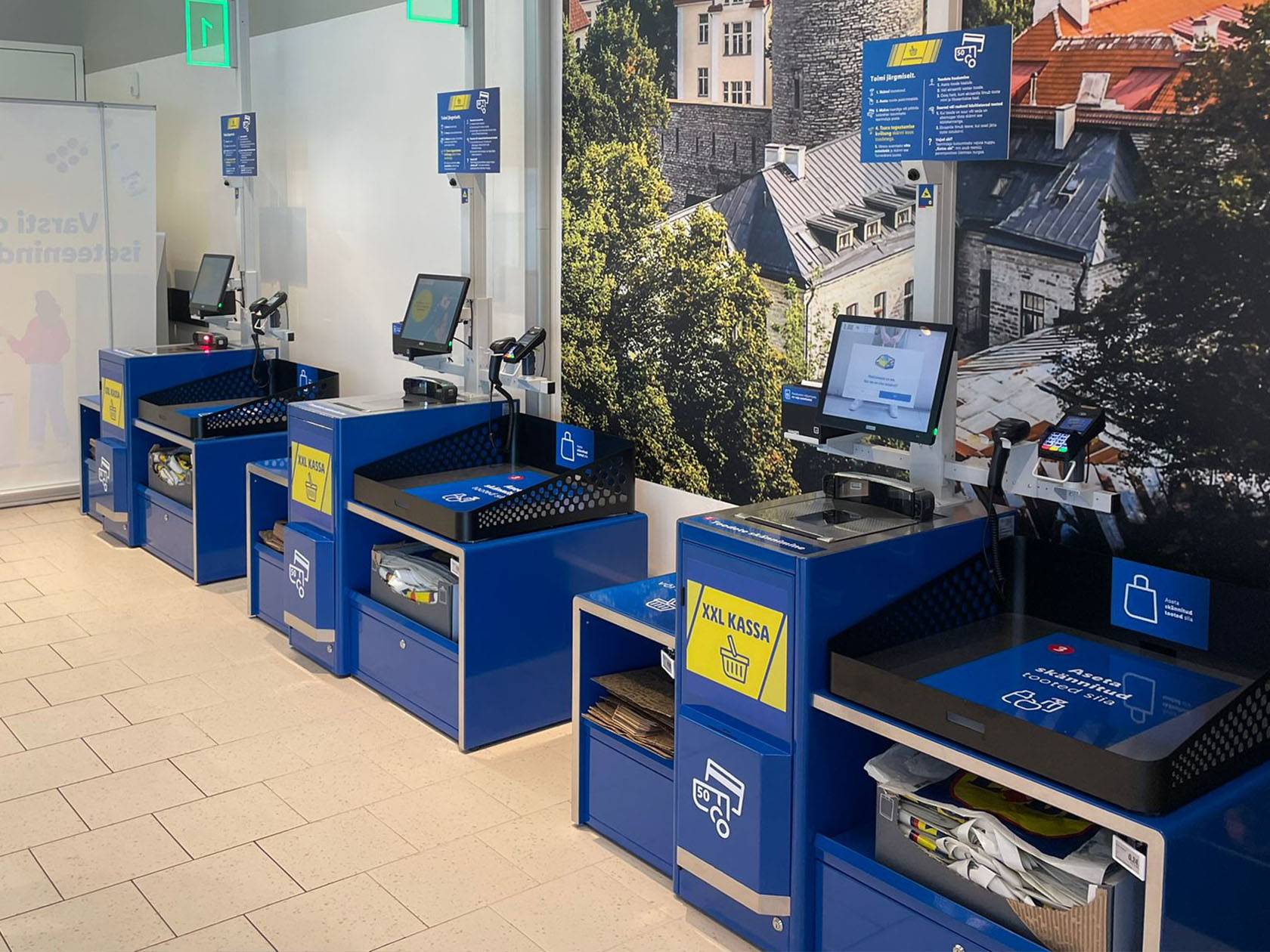 Современные кассы самообслуживания в магазине Lidl с большими экранами и сканерами штрих-кодов.