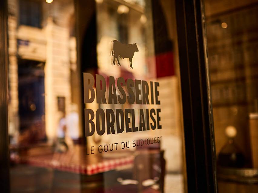 Brasserie Bordelaise'i silt lehma siluetiga ja tekstiga 'Le Goût du Sud-Ouest'.