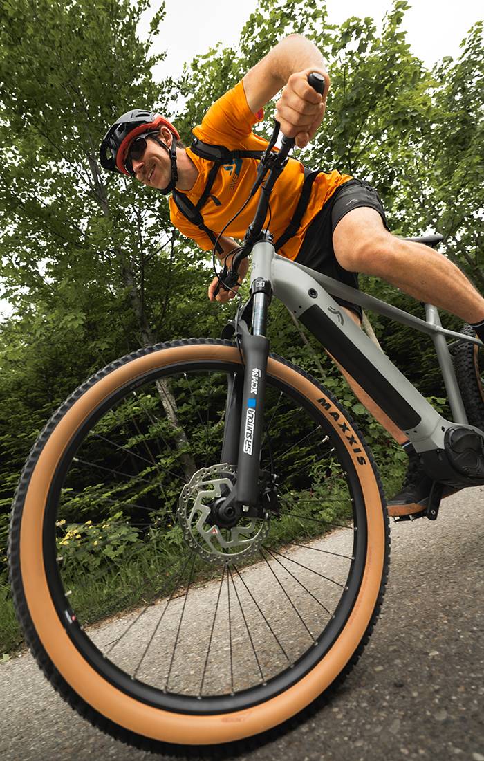 Mees sõidab halli Maxxis e-rattaga metsas.
