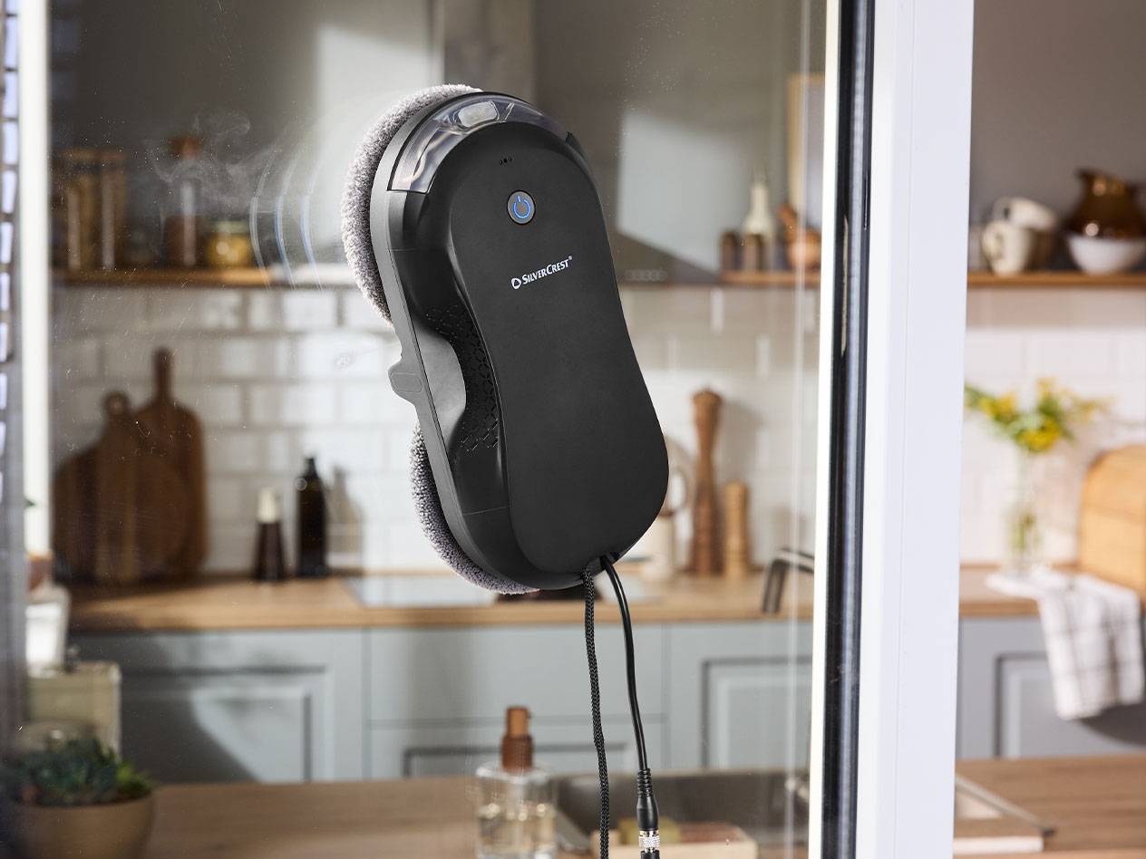 Silvercrest aknapesurobot aknaklaasil, taustal köök.