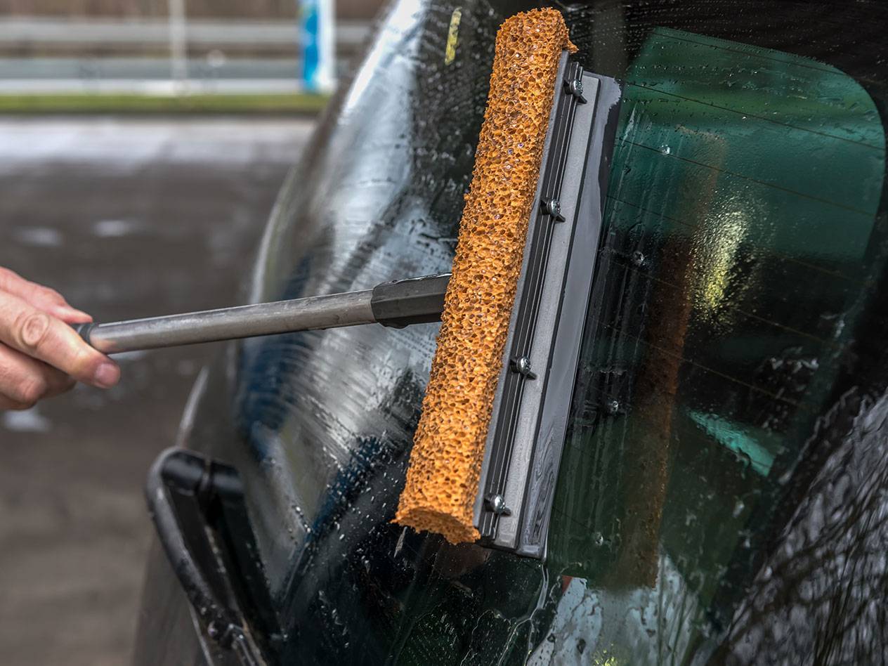 Pika varrega aknapesur puhastab auto tagaklaasi.