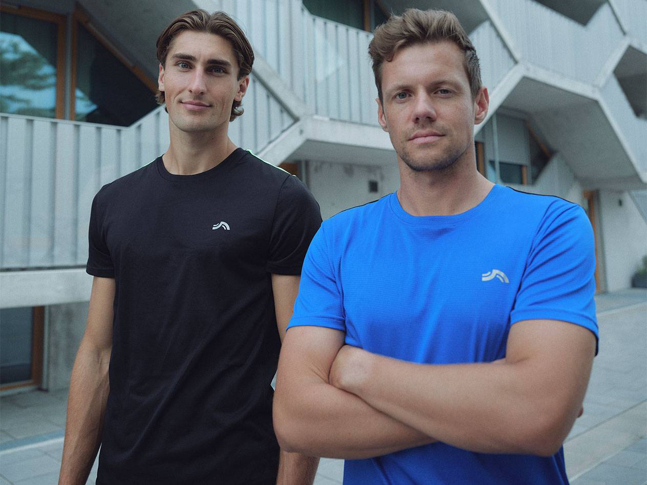 Kaks meest mustades ja sinistest logoga spordisärkides.