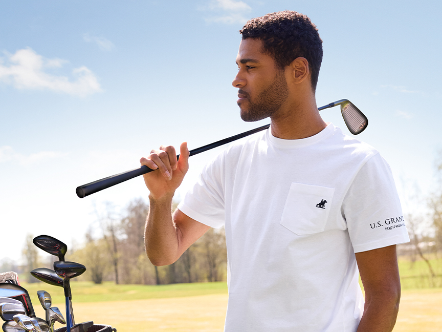 Mees U.S. Grandi T-särgis kannab golfiraudu.