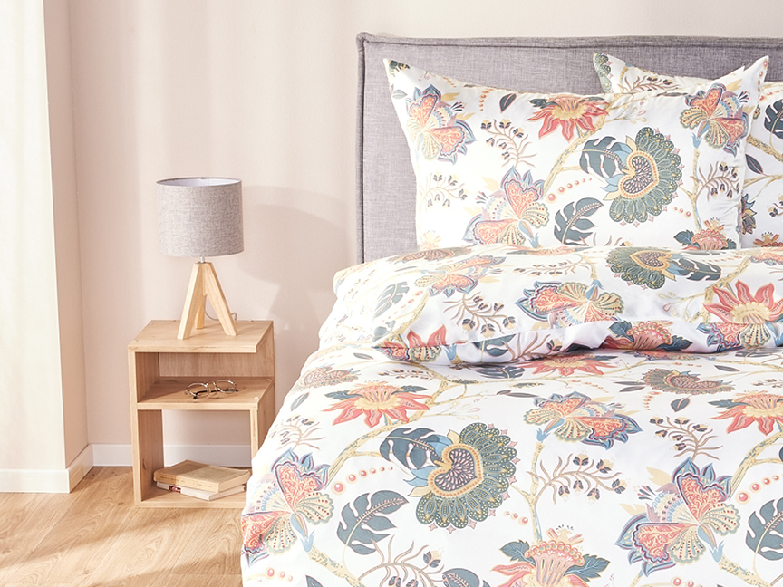 Lillelise mustriga voodipesu komplekt on elegantselt paigutatud voodile, öökapil on stiilne lamp.