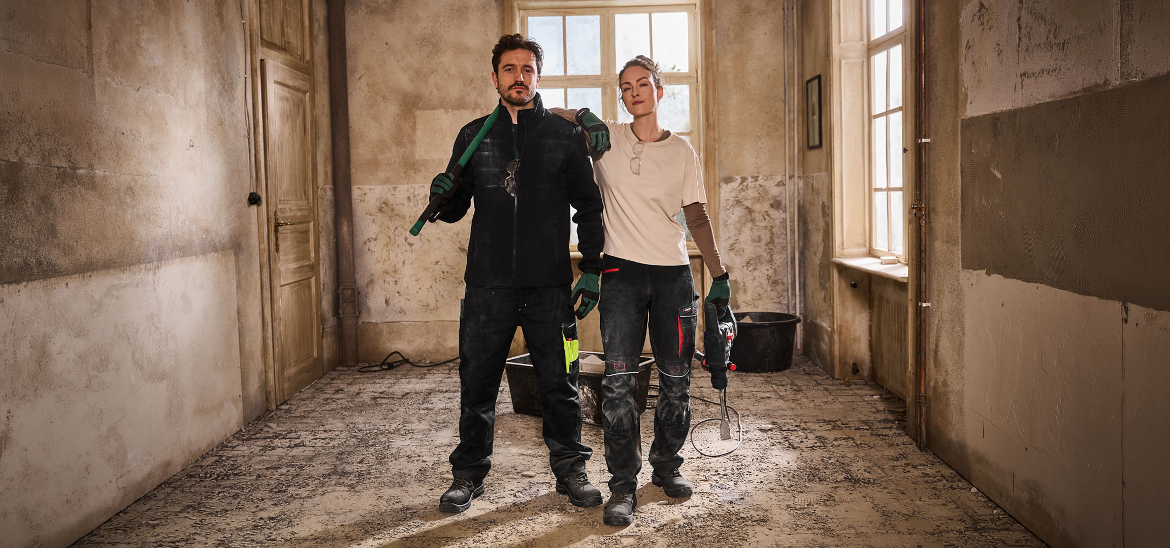 Kaks ehitustöölist tööriietes tööriistadega ehitusplatsil.