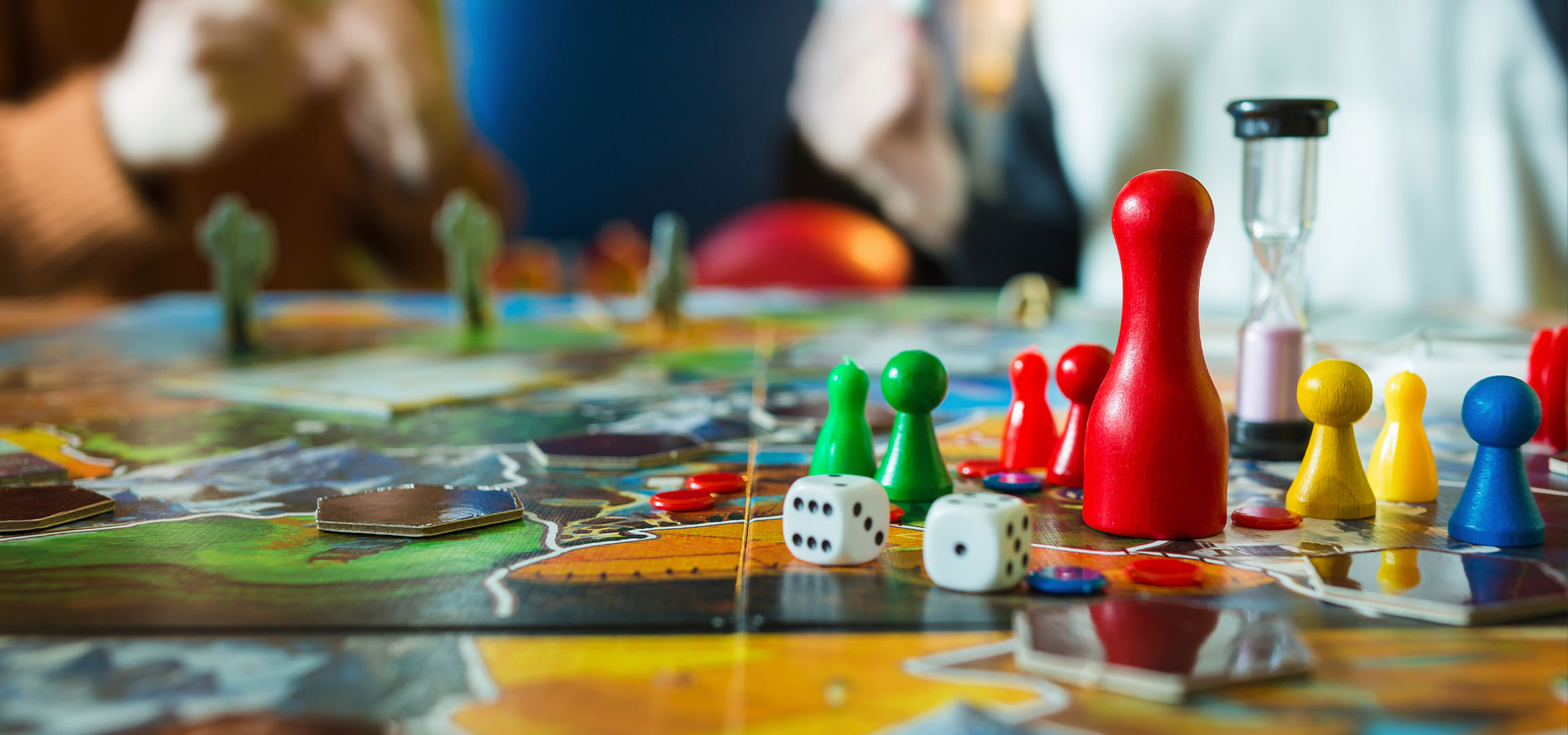 Красочные фишки для настольной игры, включая красные, зеленые, желтые и синие пешки, с кубиками.