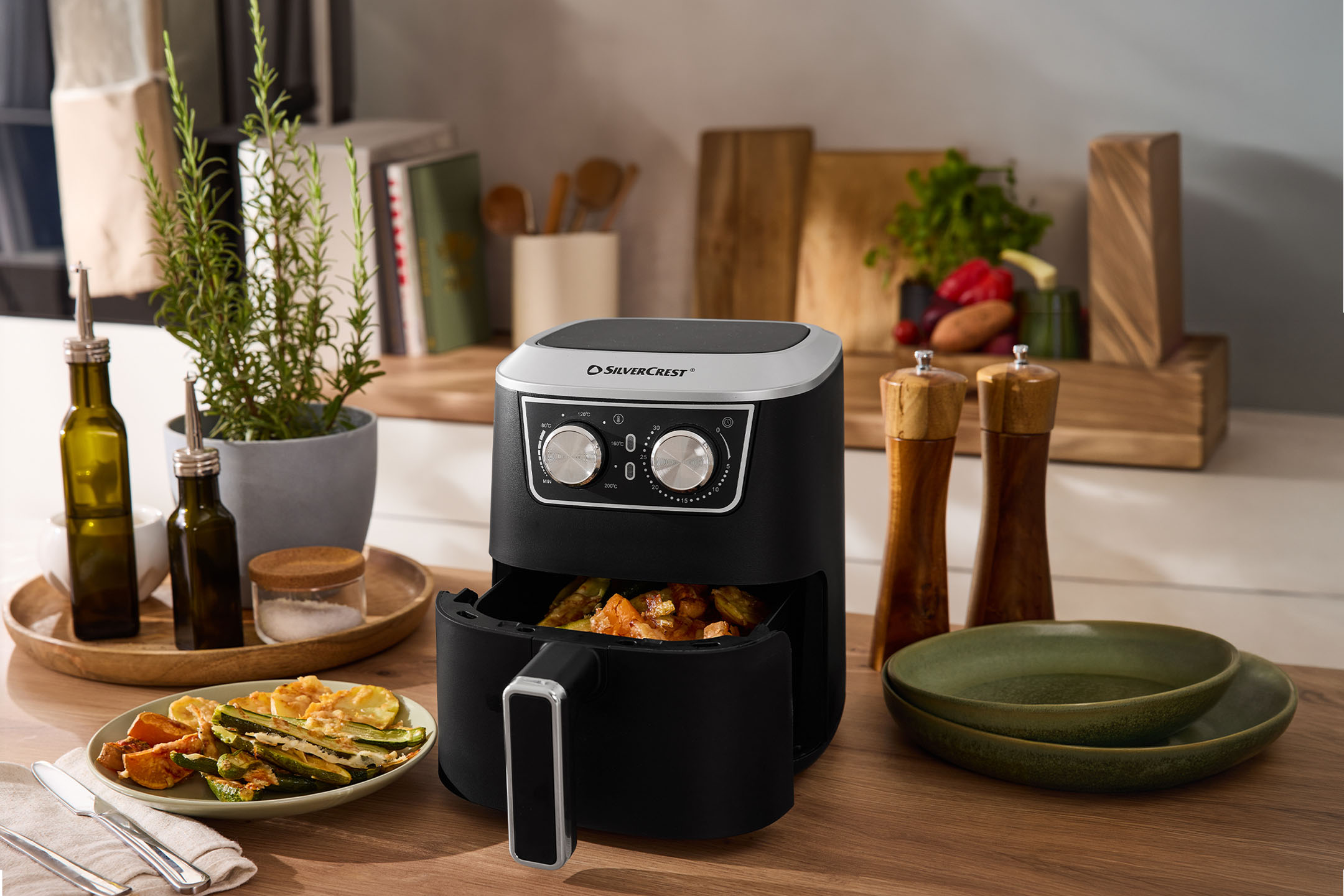 Õhufritüür röstitud köögiviljade, oliiviõli, soola ja pipraga köögiletil.