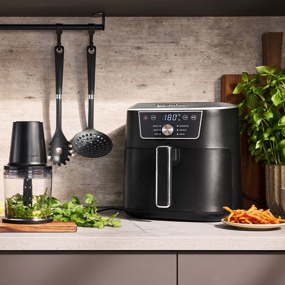 SilverCrest õhufritüür ja köögikombain köögiletil värskete ürtide ja bataadifriikartulitega.