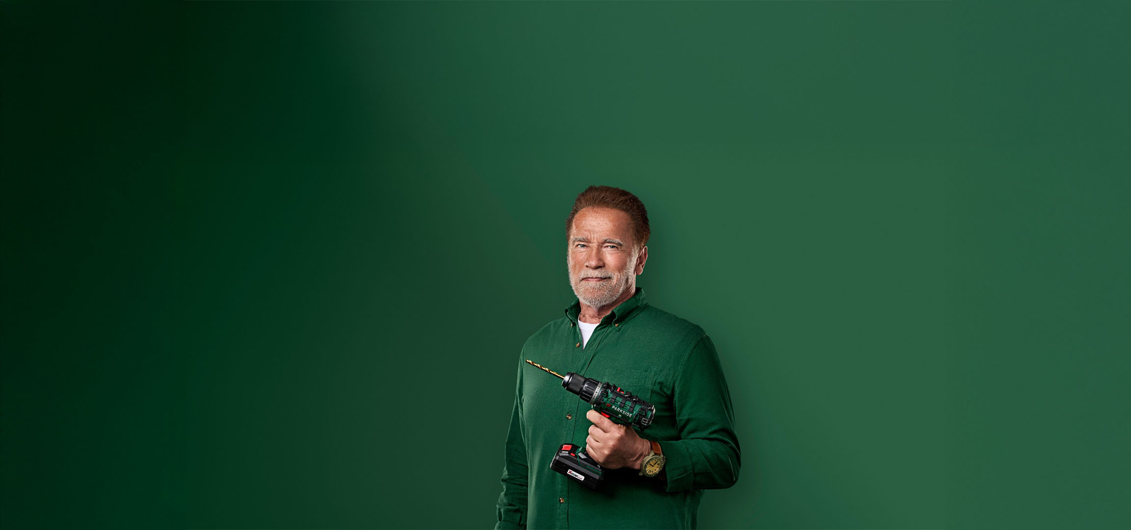 Arnold Schwarzenegger hoiab Parkside puurit rohelisel taustal.
