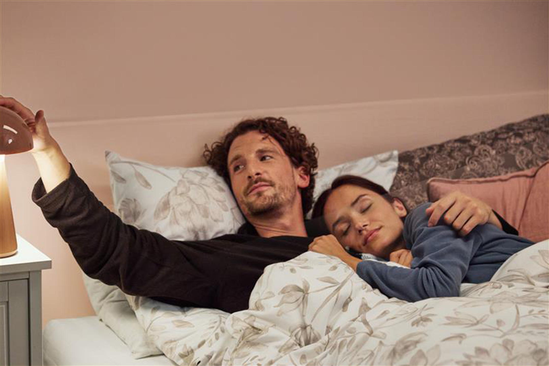 Mees lülitab öölambi välja, naine magab kõrval voodis voodipesu all.