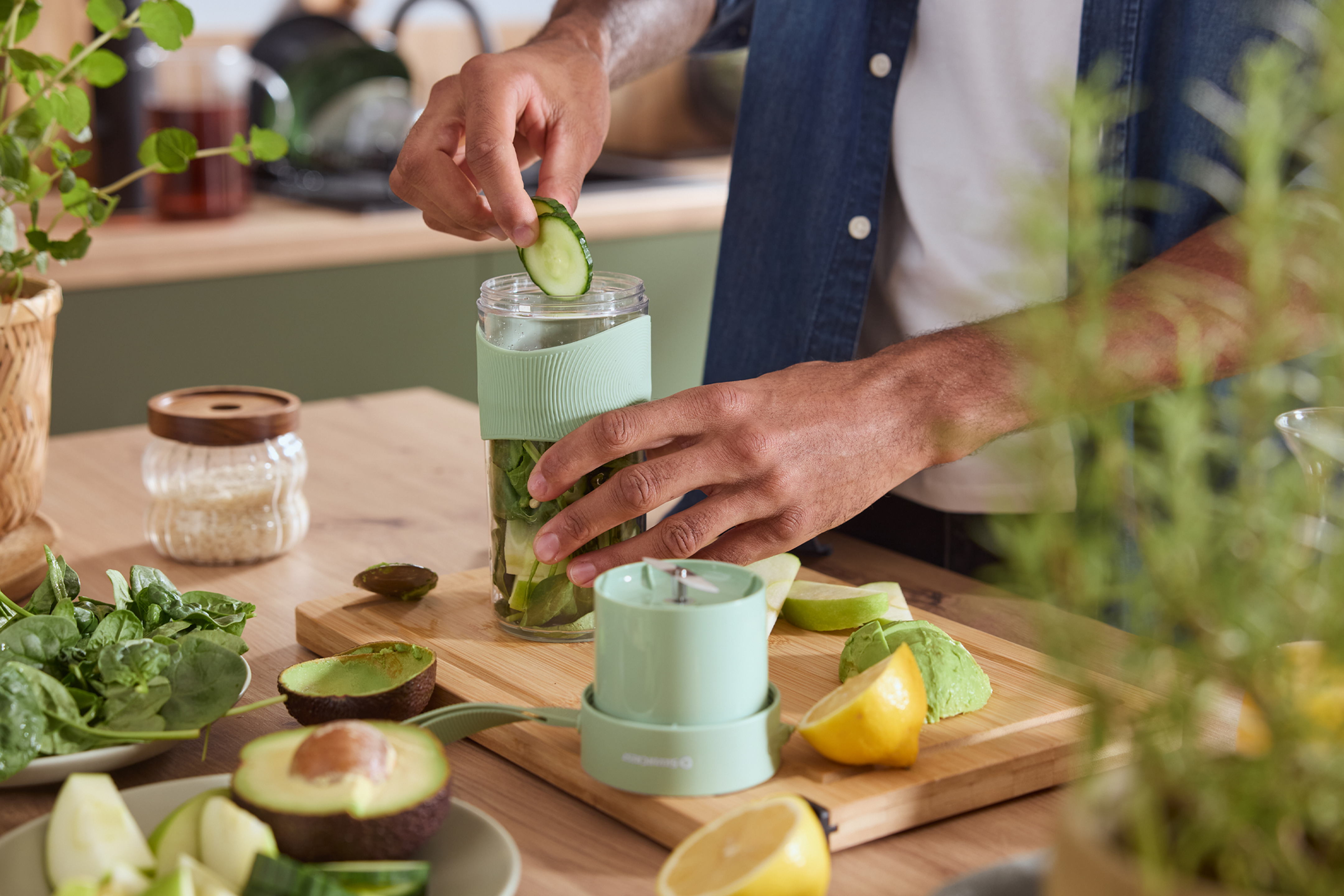 Mees valmistab smuutit, lisades kurki kaasaskantavasse blenderisse, kõrval on puu- ja köögiviljad.