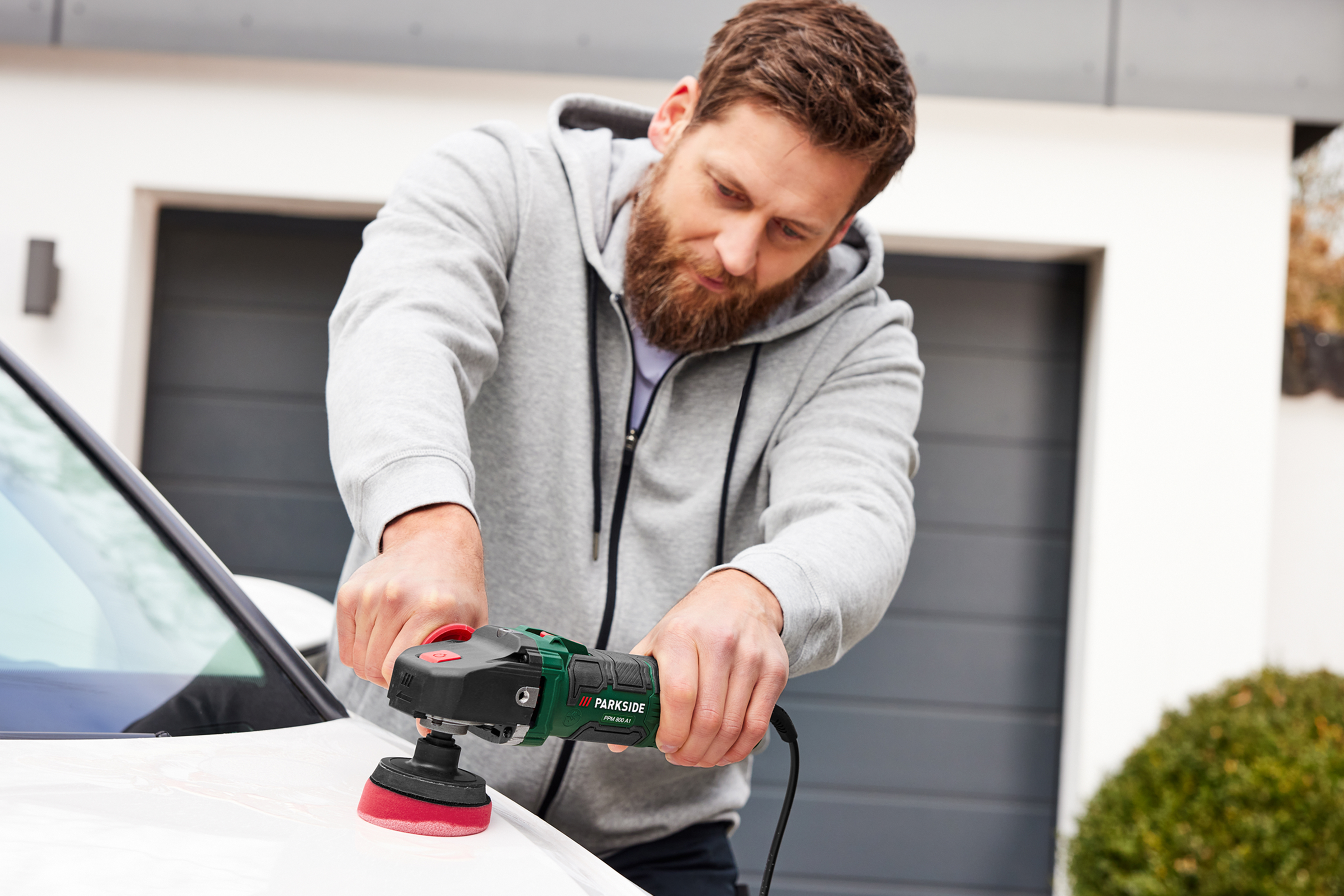 Mees poleerib valget autot Parkside'i poleerimismasinaga.
