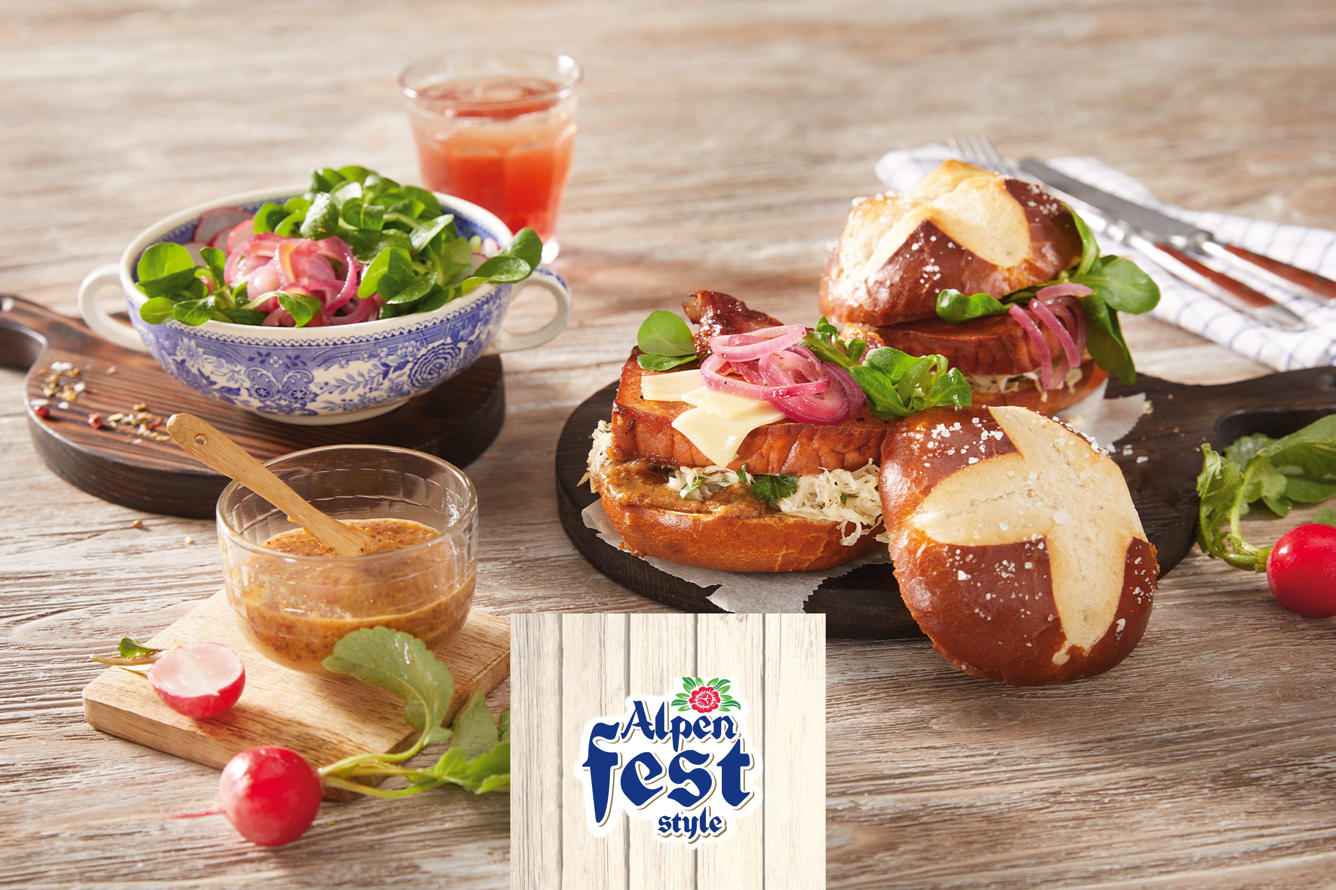 Alpenfest stiilis leivakotikesed, salat ja kaste puidust laual.