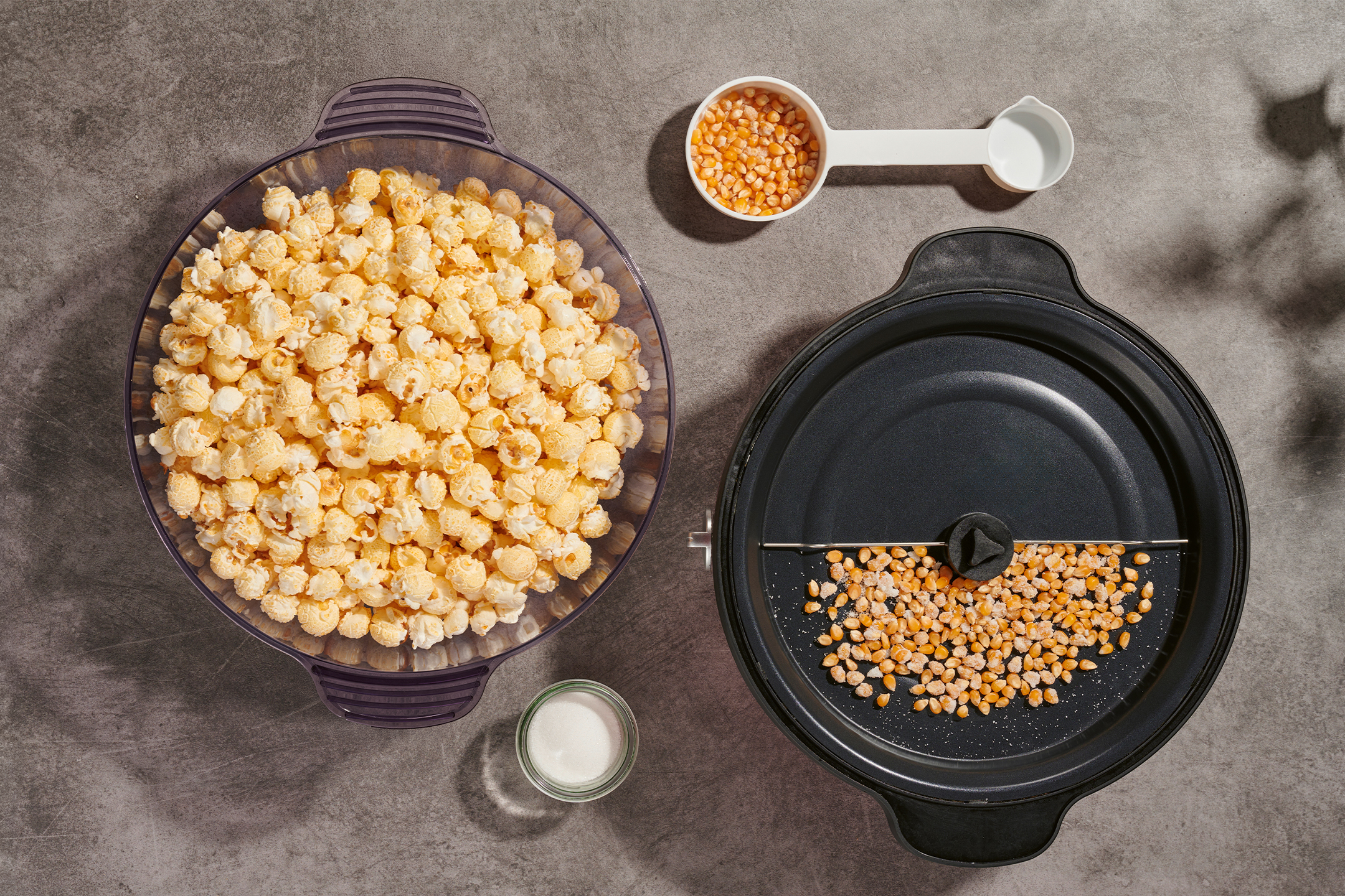 Popkorn kausis, maisiterad popkornimasinas ja mõõtelusikas, suhkur.