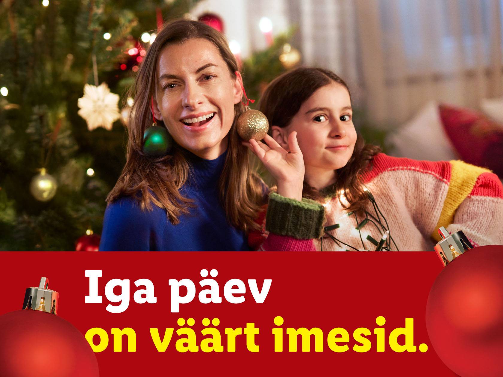 Мать и дочь с рождественскими украшениями, текст: «Каждый день достоин чудес».