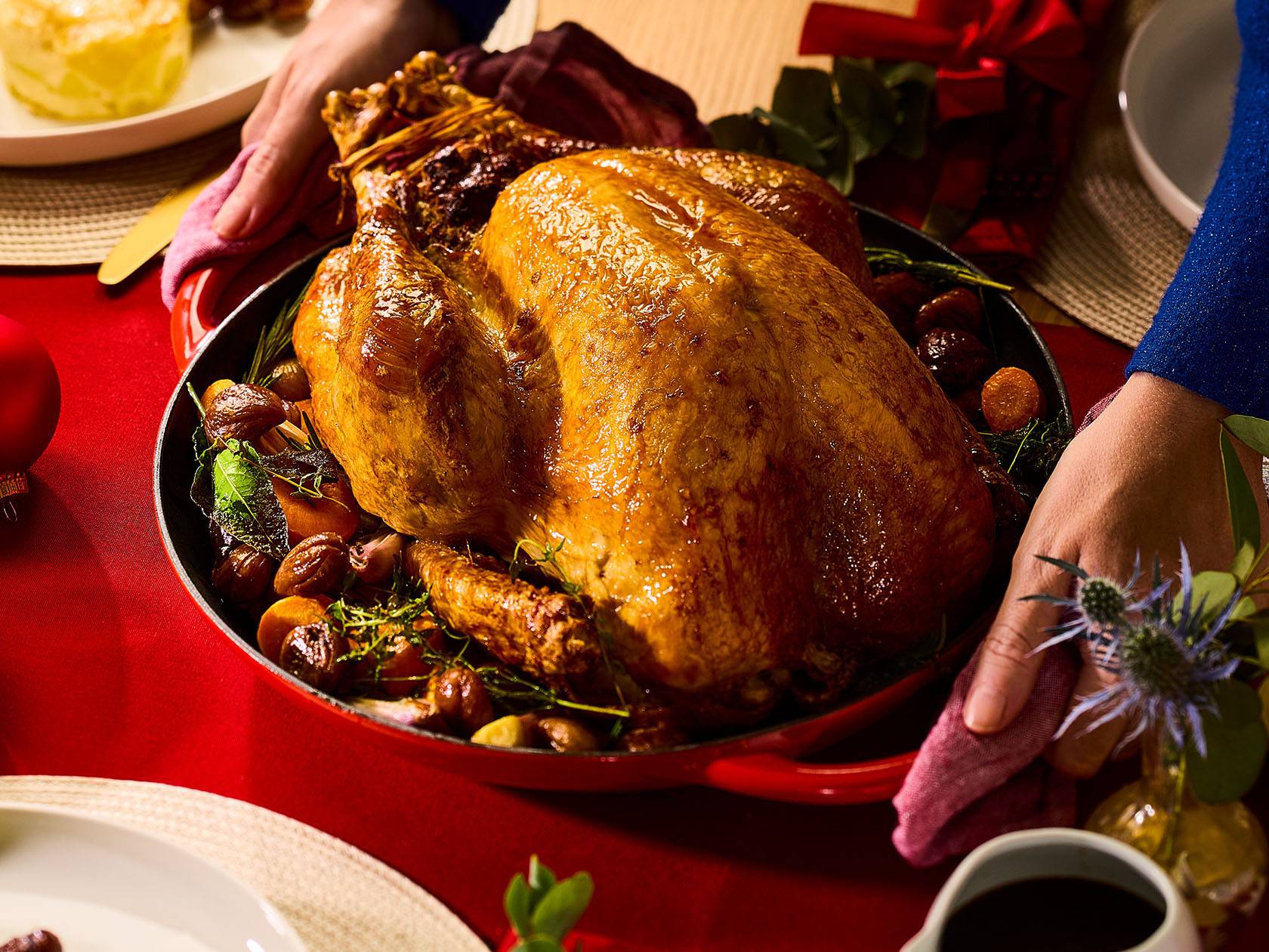 Запеченная индейка с каштанами и овощами на праздничном столе.