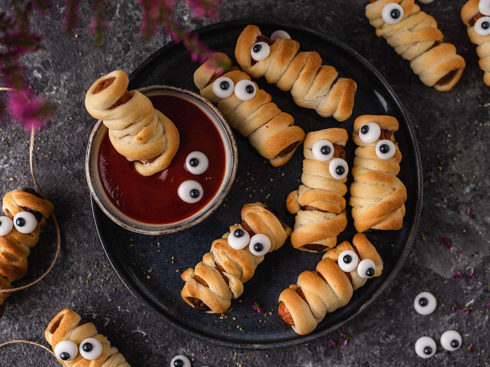 Halloweeni vorstimuumia suupisted ketšupiga tumedal taldrikul.
