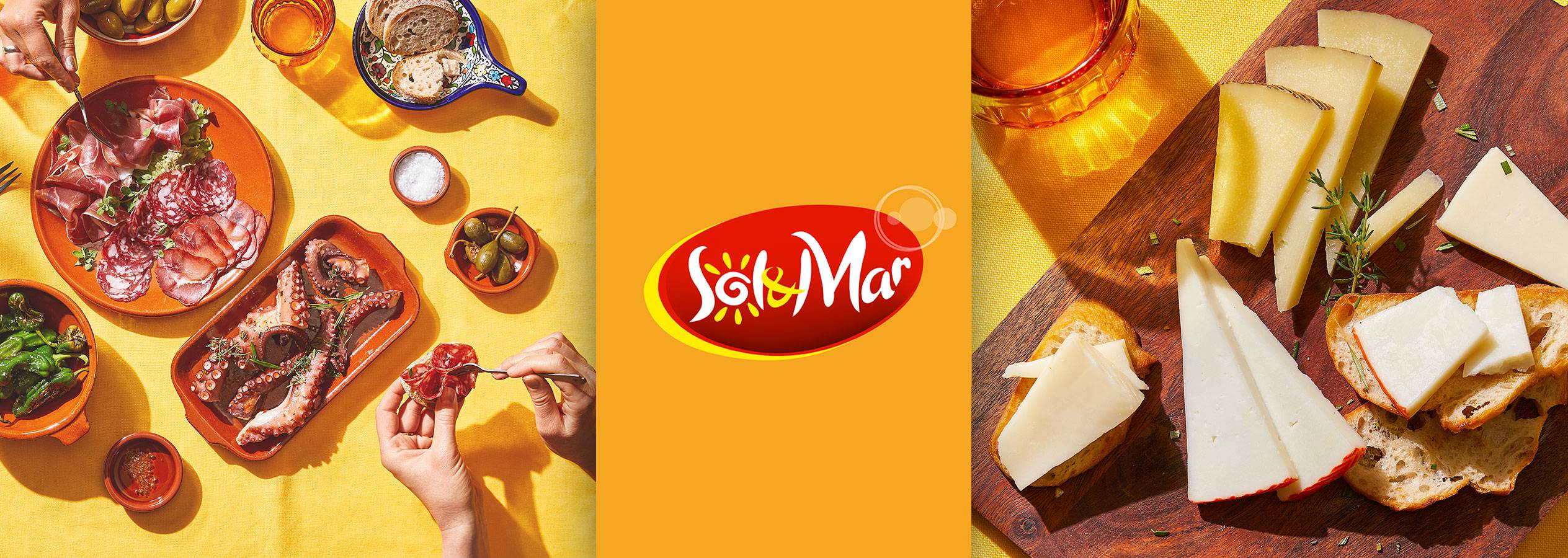 Стол с различными тапасами: колбасы, осьминог, сыры и хлеб.